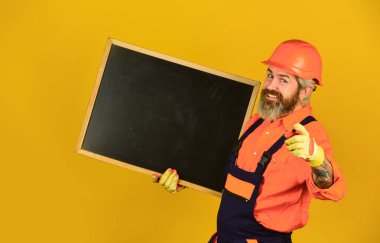 Profesyonel yetenekler. İnşaatçı adam ters çizelgeye gülümser. Mühendis projesi, uzayı kopyala. Mimar ve mühendislik çizimi. Müteahhit sunum yapıyor. İnşaat için karatahta planı sunumu