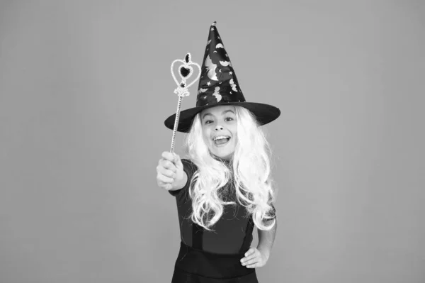 Njuter av bekymmersfri tid. tro på magi. leende liten flicka halloween fest. Mystiska häxor utför magi. liten barnhäxa hatt. trick eller godis. Barnet förtrollar vågtrollspö. Glad halloween — Stockfoto