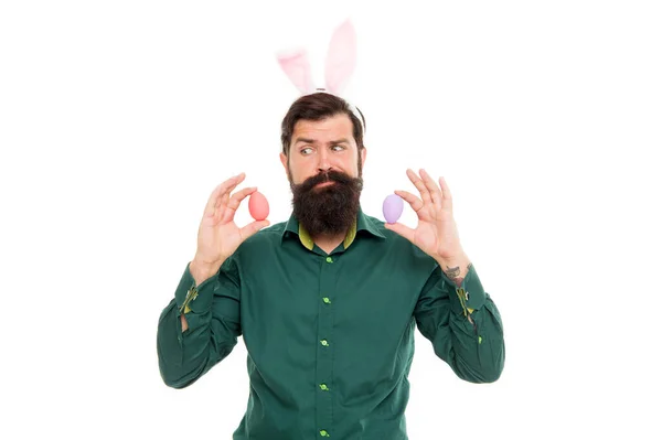 Культурні звичаї та традиції. Сезонні товари. Святкування весняного свята. Бородатий чоловік з кролячими вухами та великодніми яйцями. Хіпстер з довгими вухами тримає яйце. Пасхальний кролик з кольоровими яйцями — стокове фото