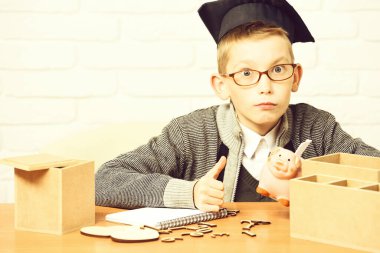 Beyaz tuğlalı duvar arkasında küçük tatlı bir öğrenci.