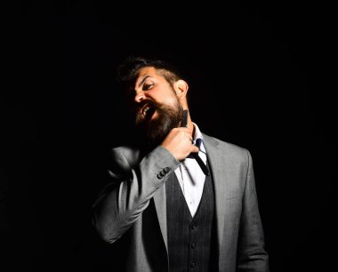 Macho in formal suit shaves beard. Businessman with furious face