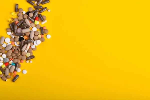 Las píldoras bordean el amarillo, copian espacio. Concepto de medicina y tratamiento — Foto de Stock