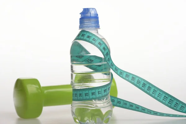 Equipo de régimen saludable. Botella de agua atada con cinta métrica cyan — Foto de Stock