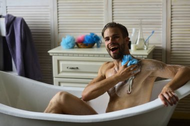 Maço küvette çıplak oturuyor ve gülüyor, seçici odaklanıyor.