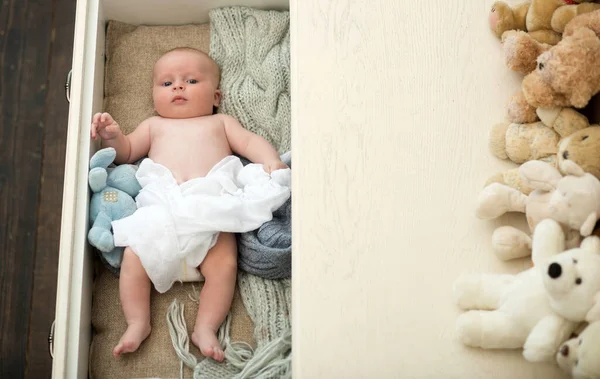 Newborn toddler with peaceful face lies on soft knitted blankets — Stock Photo, Image