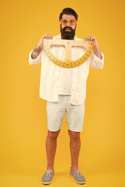 Derse hazır olmak. Sakallı adam matematik dersi için protractor tutarak. Matematik öğretmeni veya geometri dersine hazırlanan öğrenci. Hipster okul dersinde ölçüm aleti kullanarak
