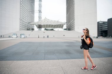 Yaz tatili. Gezi rehberi. Kız turist güneş gözlükleri şehir merkezinin tadını çıkarıyor. Kadın şehir mimarisinin önünde duruyor. Ziyaret etmeliyim. Turistler için rehber. Şehri keşfeden sırt çantalı