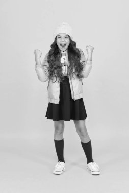 Sonunda başardım. Modern kıyafet. Sevimli okul kızı kış kıyafeti. Sırt çantalı kız öğrenci kıyafeti. Moda aksesuarı. Kız gülen surat, küçük şık şirin kız örgü şapka ve ceket giyiyor.