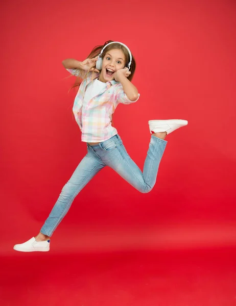 Saltando en el aire. Feliz niña bailando. Lindo niño disfrutando de música de baile feliz. La música es felicidad para ella. Música fácil de escuchar. Niña escuchando música en auriculares. Bailarina — Foto de Stock