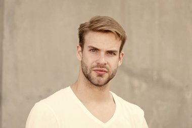 Kendini sev. Erkek çekiciliğinin portresi. Genç, seksi, gri arka plan. Tıraşsız maço adam. Yaz erkek modası. Öğrenci traşsız, stil sahibi saç stili. Sakallı adam, sıradan bir tarz.