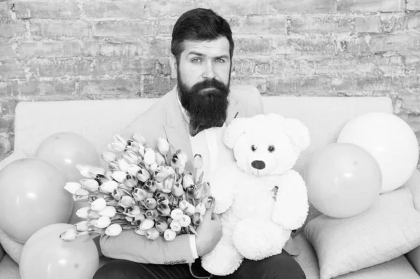 Man well groomed wear tuxedo bow tie hold flowers tulips bouquet and big teddy bear toy. Invite her dating. Romantic gift. Romantic man. Macho getting ready romantic date. Waiting for darling — Stock Photo, Image