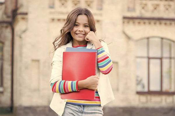 Kind glimlachende meisje school student houden werkboeken leerboeken voor het studeren. Onderwijs voor begaafde kinderen. Succesvolle leerling. Extra cursus volgen voor dieper leren. Schoolonderwijs. Modern onderwijs — Stockfoto