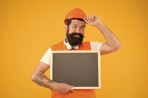 A anunciar serviços. Construtor Foreman conceito. Trabalhador construtor rosto barbudo. Construtor de capacete. Instalar e reparar tubos e acessórios de abastecimento de água. Homem chapéu duro segurar chalkboard copiar espaço — Fotografia de Stock