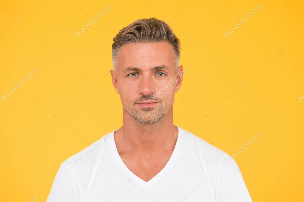 Handsome and charismatic. Handsome guy yellow background. Unshaven man with handsome face. Skincare products. Hair and skin care. Haircare cosmetics. Mens grooming. Handsome and well groomed