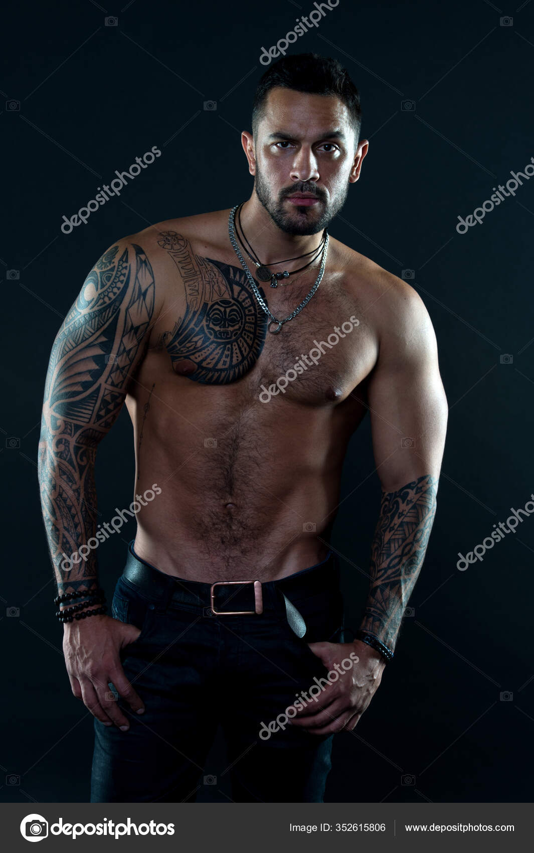 Jewelry for real men. Bearded man with tattooed torso. Macho sexy bare  torso. Fit model with