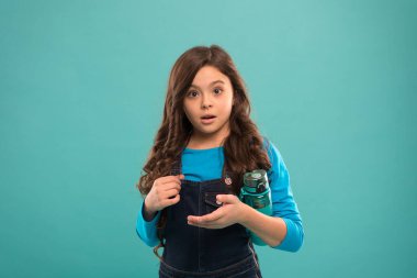 içme suyu susuzluğu önler. Küçük kız şişeyi tutuyor. Detoks ve insanlar. Genç çocuk için sağlıklı bir içecek. Sağlık ve vücut dengesi için içme suyu. Susamış çocuk su iç.