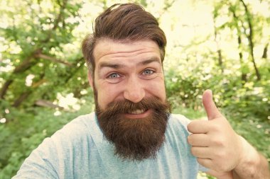 Berberine baş parmak işareti yapıyor. Doğal manzarada mutlu berber hareketleri. Sakallı ve bıyıklı sakallı adam berbere gitmeden önce ya da sonra gülümsüyor. Sadece erkekler için bir berber dükkanı.