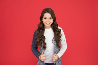 Sevimli bir gülümseme. Doğal bukleler. Çocuk şirin, sevimli, kıvırcık saçlı. Uzun saçlı, kendine güvenen bir çocuk. Kıvırcık saçlı kız kendine güveniyor. Çocuk psikolojisi ve gelişimi. Kendinden emin duruş