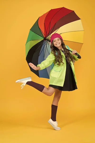 İyi eğlenceler. Pozitiflik kavramı. Yağmurlu gün eğlencesi. Şemsiyenin altında mutlu bir yürüyüş. Yağmur konseptinin tadını çıkarın. Çocuk kız mutlu renkli gökkuşağı şemsiye tutun. Uygun giysiler ile yağmurlu hava. Parlak şemsiye — Stok fotoğraf
