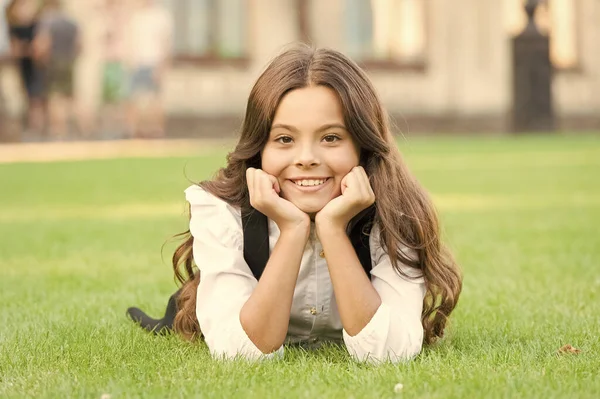 Drömmer om framtiden. Glad flicka koppla av på grönt gräs. Ett litet barn med gulligt leende. Framtida generation. Utbildningens framtid. Utbildning ger kunskap och bättre framtid — Stockfoto