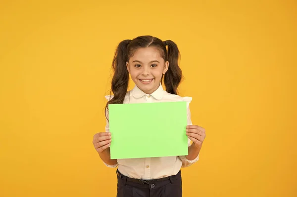 İşte ödeviniz. Sarı arka planda boş ev ödevi sayfası tutan sevimli küçük çocuk. Ev ödevi yapmak için boş yeşil okul kağıdı ile sevimli küçük kız. Ödev, kopyalama alanı — Stok fotoğraf