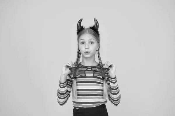 不気味な休日の外観を作成します。小さな女の子はハロウィンの休日の衣装アクセサリーを着ている。休日のパーティーのために悪魔の格好をした小さな子供。お祝いだ。ハロウィンシーズン — ストック写真