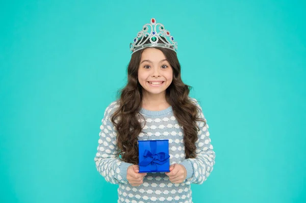 Portrait of cute smiling little girl with gift box. kid in princess crown. happy birthday daughter. Birthday Princess. Kid silver crown symbol of glory. portrait of pride. happy childrens day