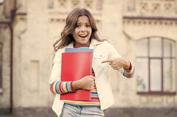 Olha para isto. Menina feliz apontando o dedo para os livros. Criança pequena sorrindo e apontando para a capa dos livros. Usando gesto de apontar para direcionar a atenção. Estendendo o dedo e apontando — Fotografia de Stock