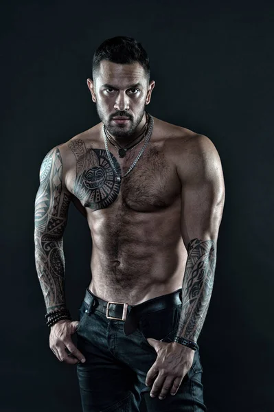 Güçlü ol. Vücut dövmesi olan kaslı bir vücut geliştirici. Atletik erkek karın kasları gösterir. Fitness modeli üstsüz. Sağlık hizmeti yaşam tarzı. Vücut kasları güçlü. Vahşi erkeksi güzellik. Maço. vahşi ve seksi