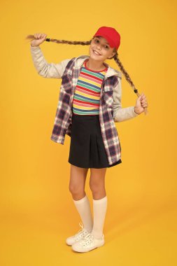 Saç modelinin bütün gün sürmesini sağlamak. Saçları örülmüş, sarı bir geçmişi olan mutlu çocuk. Uzun saçlı, küçük tatlı kız gülüşü. At kuyruklu saç stili modası.