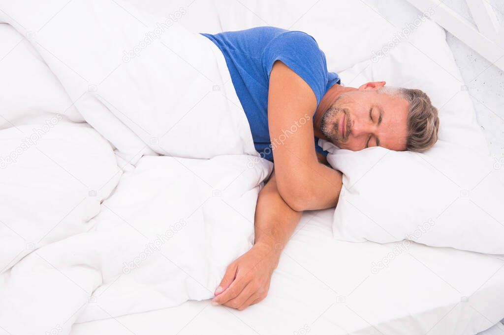 Sexy man lying on bed with soft pillows at home. Perfect morning. Tips sleeping better. male health. Enjoying time at home. Relaxing in bedroom. day dreaming male. Day sleeping. Morning of a new day