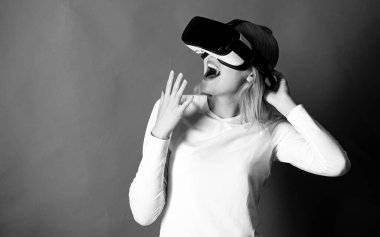 Sanal gerçeklik gözlüklü kadın. VR 'da siber eğlence deneyimi yaşayan bir kadın. Sanal gerçeklik kulaklığı kullanan bir kadın. Simülasyon VR.