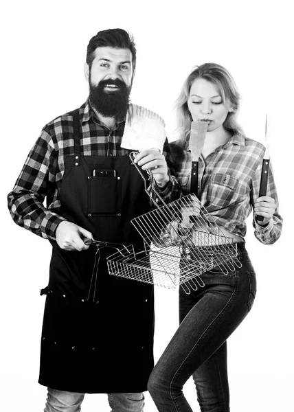 Pareja en el amor mantenga utensilios de cocina para barbacoa. Herramientas para asar carne al aire libre. Picnic y barbacoa. Concepto culinario. Hombre barbudo hipster y chica listo para la fiesta de barbacoa. Fin de semana familiar — Foto de Stock