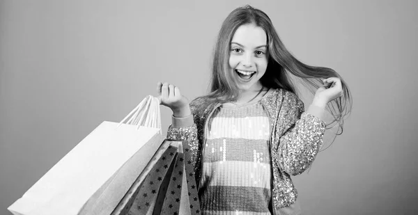 Después de comprar. oferta especial. Ahorro de compra vacaciones. Ventas y descuentos. Moda infantil. asistente de tienda con paquete. Niña pequeña con bolsas de compras. Feliz niña. Niña con regalos —  Fotos de Stock