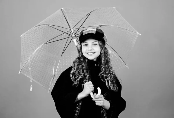 cheerful hipster child in positive mood. rain protection. Rainbow. autumn fashion. happy little girl with transparent umbrella. little girl in french beret and coat. Feeling free and relaxed