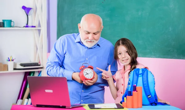 Late to school. education blogging. Back to school. small girl with man tutor study on computer. break alarm. Morning. time to study. school lesson online. mature teacher help pupil with clock — Stock Photo, Image