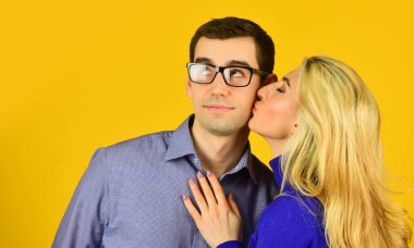 Erkek ve kadın kucaklaşır. Zeki görünümlü adam gözlük takıyor. Seksi bonde kızı öpüyor ve erkek arkadaşına sarılıyor. Romantik ilişki kavramı. Aşk ve randevu. Mutlu aile günleri. Birbirine aşık çiftler. Sevgililer günün kutlu olsun.