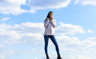 Şehir caddesinde ceket giyen bir kız. Açık havada şık bir manken. İnsanların özgürlük tarzı. Kış sıcacık giysileri. Sıradan kot giyen bir kız. Güneşli günün ve mavi gökyüzünün tadını çıkarıyor. güzellik ve moda