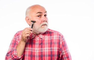 Havalı ve modaya uygun. Tıraşsız yaşlı adamın bıyığı ve sakalı var. Beyaz sakallı, olgun bir adam. Kes ve saç fırçala. Tıraş bıçağı alet çantası. Berber dükkanı konsepti. Traş aksesuarları. Boşluğu kopyala