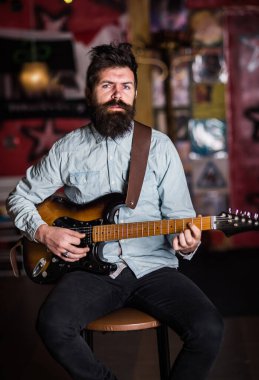 Teşvik edici bir kavram. Sakallı müzisyen elektro gitar enstrümanı çalıyor.