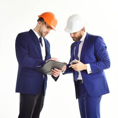 Ciddi yüzlü mühendisler. Planları ve akıllı telefonu olan girişimci ve mimar.