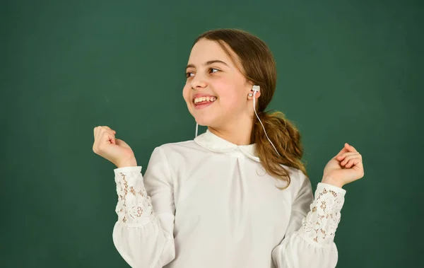 Inspired with music. e-learning concept. home schooling online education. back to school. small girl in headphones at blackboard. listening audio book. cool girl in headphones listening to music — Stock Photo, Image