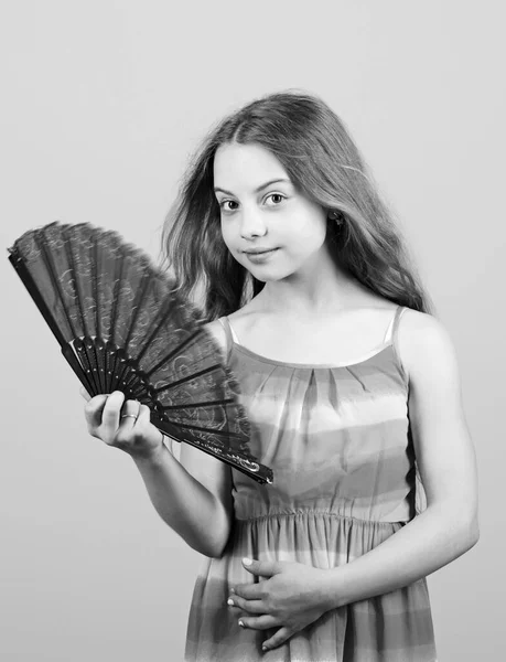 Summer heat. Fresh air. Kid girl fanning herself with fan. Cooling and ventilation. Conditioning system. Climate control. Air conditioner. Waving to create current air. Little girl waving elegant fan — ストック写真