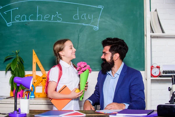 Saludos para el pedagogo escolar. De vuelta a la escuela. Mis mejores deseos. Felicitaciones del día del conocimiento. Niña adorable alumno con mochila dando ramo de flores profesor. Vacaciones escolares. Colegiala agradecida — Foto de Stock