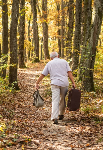 Her zaman çantan hazır olsun. Yaşlı kişi seyahat çantası taşıyor. Yaşlı adam retro çanta ile seyahat ediyor. Serseri hayatı yaşamak. Tatil ve seyahat. Seyahat tutkusu. Evim, çantamın düştüğü yerdir. — Stok fotoğraf