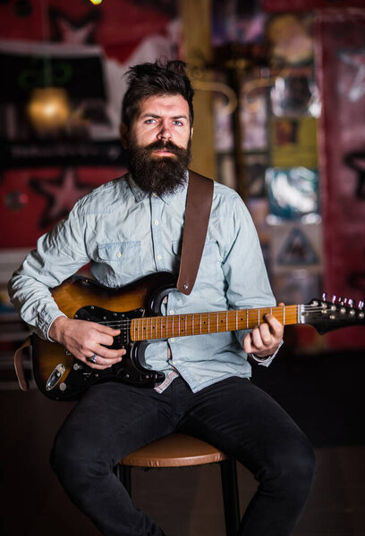 Инструменталистская концепция. Музыкант с бородой играет на электрогитаре
.