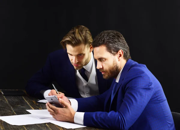 Az aggódó arcú öltönyös férfiak üzleti híreket olvasnak.. — Stock Fotó