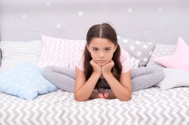 Ne kadar üzücü. Üzgün kız yatakta oturur. Üzgün bakışlı küçük bir çocuk. Uyku zamanı rutini. Gündüz uykusu. Çocukların sağlığı. Çocuk bakımı. Sabah erken saatte. İyi geceler. Mutsuz ve üzgün