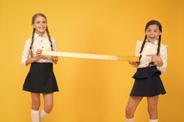 Yakın ya da uzak. Ölçme yetenekleri. Mesafeyi ölçüyorum. Ölçüm aletleri. Çocuklar matematik okuyor. Bilgi toplama günü. Okul üniformasında büyük bir cetvel var. Geometri dersi. Takım çalışması konsepti