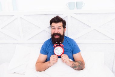 Alarmlı saatle yatakta yatan adamın mutlu uyanması. Adam uyanıyor. Sabahleyin çalar saat. Erkek Sağlığı konsepti. Bekarlığa veda günü şimdi başlıyor, sabah ereksiyonu. Yeterince sağlıklı uyku